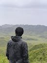 Person enjoying a panoramic view of Dzukou Valley in Nagaland, India, known for its lush hills and trekking trails.